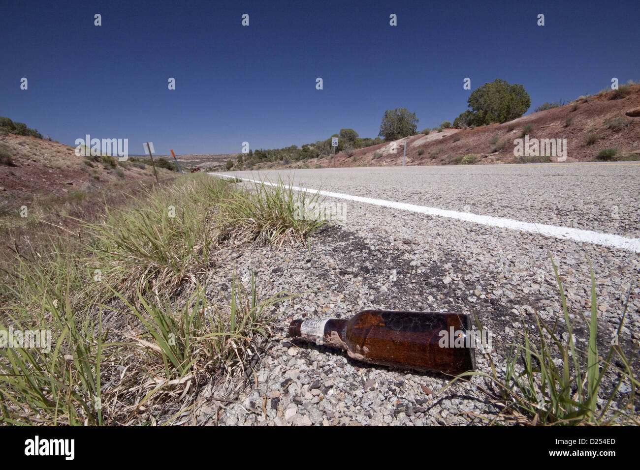 Glasflasche, die von der Seite der Straße, Gefährdung der Tier-und Pflanzenwelt und Feuer geworfen. Stockfoto