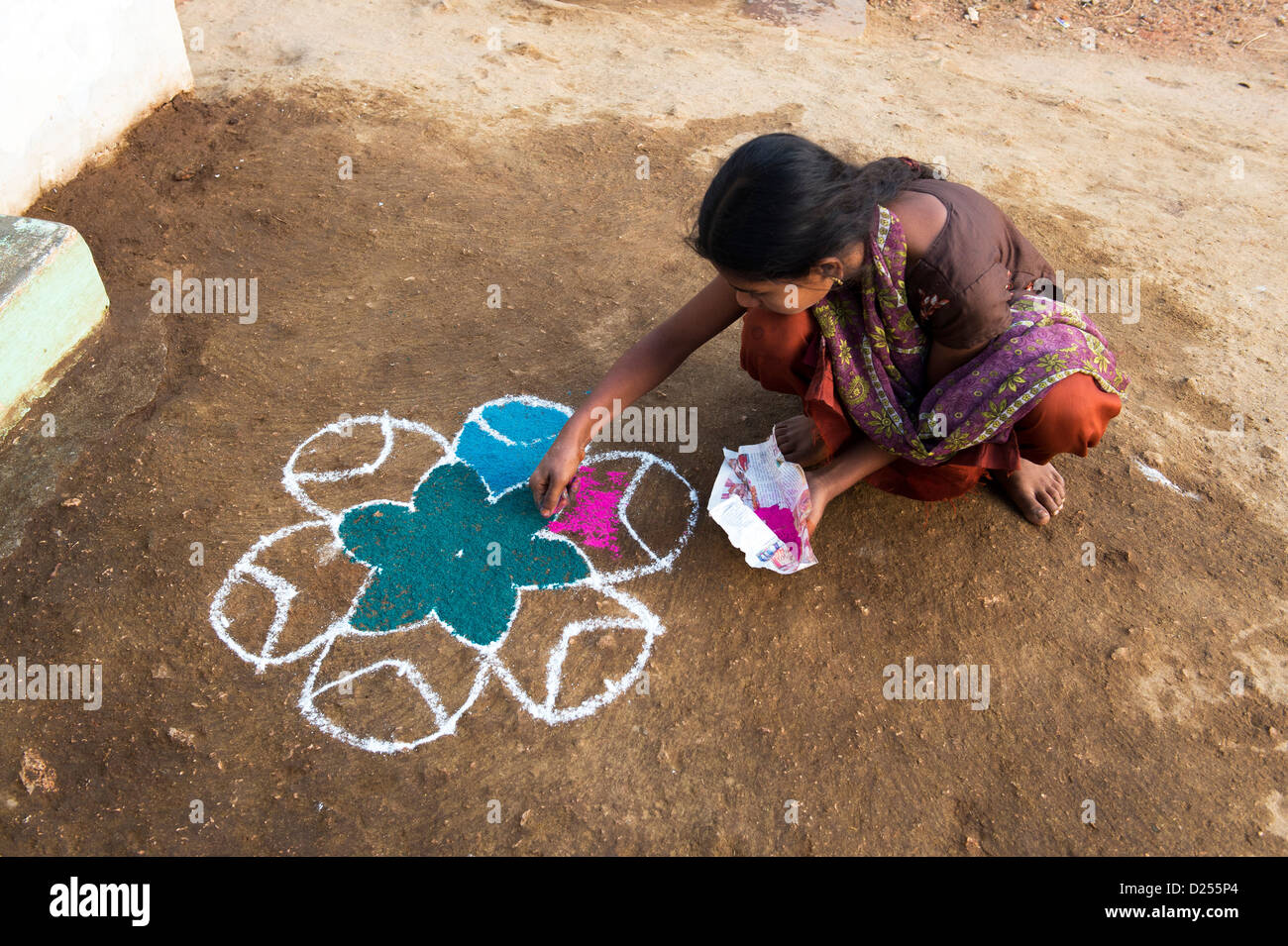 Indisches Mädchen einen Rangoli festival Design vor ihrem Haus in der Straße während der sankranthi Festival. Andhra Pradesh, Indien Stockfoto