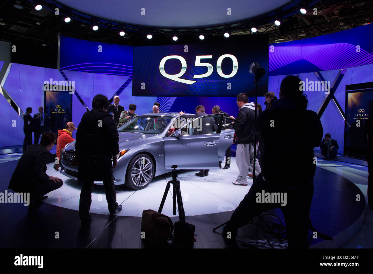 Journalisten untersuchen die Infiniti Q50 Hybrid-Sportlimousine auf dem Display auf der North American International Auto Show. Stockfoto
