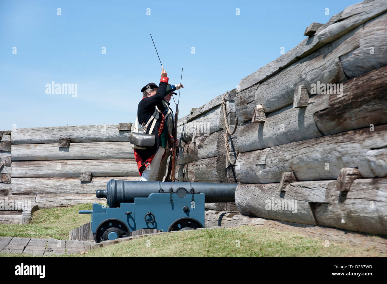 Fort Stanwix Reenactors: American Continental Artillery Soldat Muskete hinter Kastellmauern Feuer wird vorbereitet. Stockfoto
