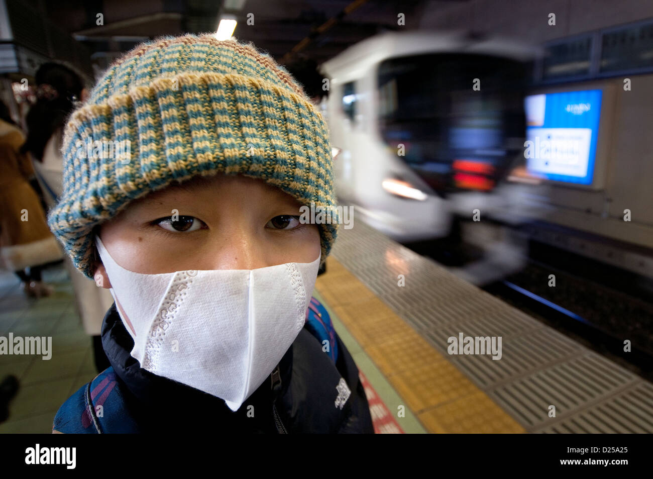 Jungen tragen eine Gesichtsmaske an einem Bahnhof in Japan Stockfoto