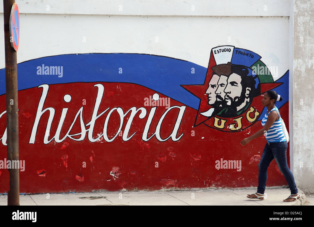 Eine Fußgängerzone spazieren vorbei an einer Wand mit einem Graffiti auf, unter anderem die Köpfe von Fidel Castro (C) und Ernesto Che Guevara (R) und dem Schriftzug "Historia" (lit.-Geschichte) in Havanna, Kuba, 21. Januar 2012 zeigt. Foto: Friso Gentsch Stockfoto