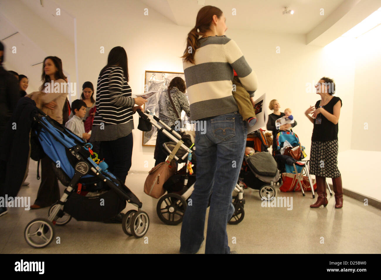Tour-Direktor Jackie Delamatre (L) steht bei Müttern und Kindern im Guggenheim Museum in New York, USA, November 2012. Museen wie das Guggenheim wollen Mütter unterhalten und sogar die jüngsten Kinder in Kunst mit den Buggy-Touren einführen. Foto: Christina Horsten Stockfoto