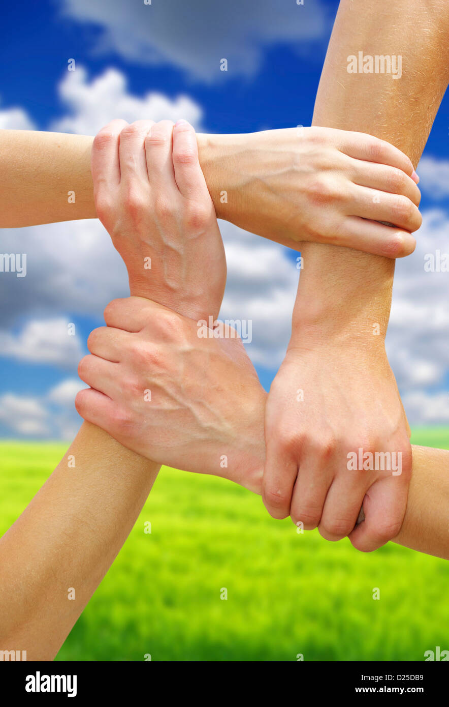 Verknüpfte Hände auf Teamarbeit und Freundschaft symbolisiert Himmelshintergrund Stockfoto