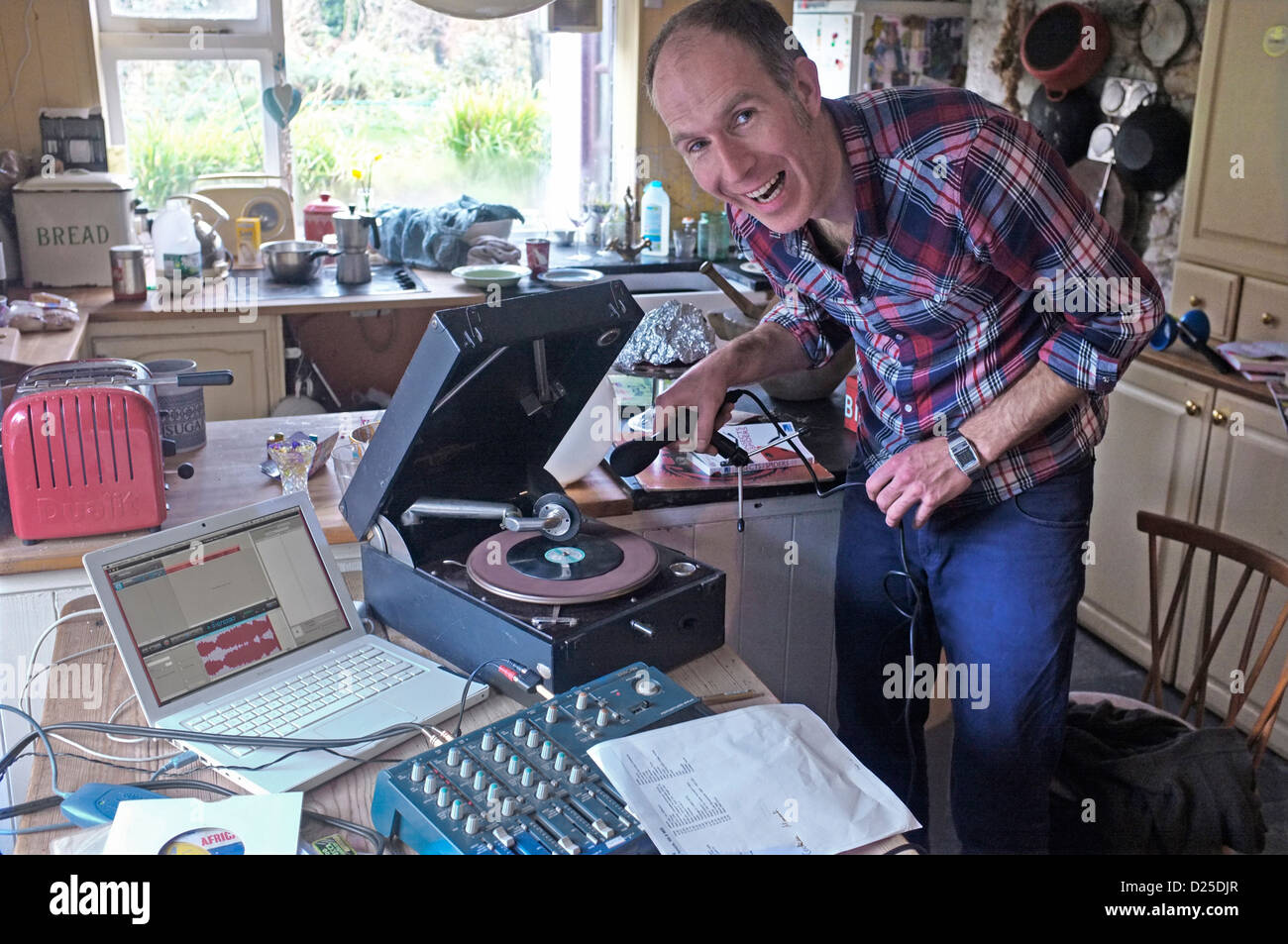 Amateur DJ zeichnet eine Radio-Show in seiner Küche. Hier zeichnet er einen Plattenspieler 78 u/min auf einen computer Stockfoto