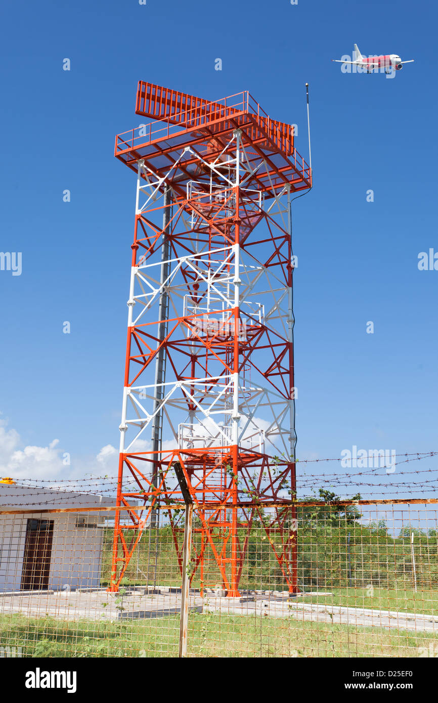 Rote und weiße Metall Radarturm im Flughafenbereich mit Flugzeug Landung Stockfoto