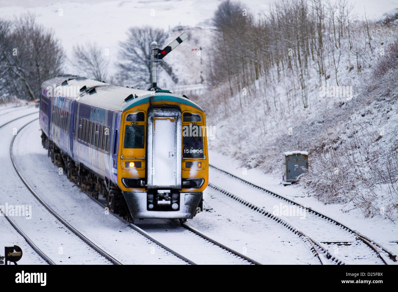 158906 Northern Rail Class 158. Schnee in Kirkby Stephen, Cumbria Januar 2013: Züge, Gleise & Passagiere & Diesel Train nähern sich dem Bahnhof, auf der Siedle Carlisle Railway. Die Eisenbahn arbeitet unter schwierigen Winterbedingungen nach nächtlichem Schneefall und eiskalten Temperaturen. Stockfoto