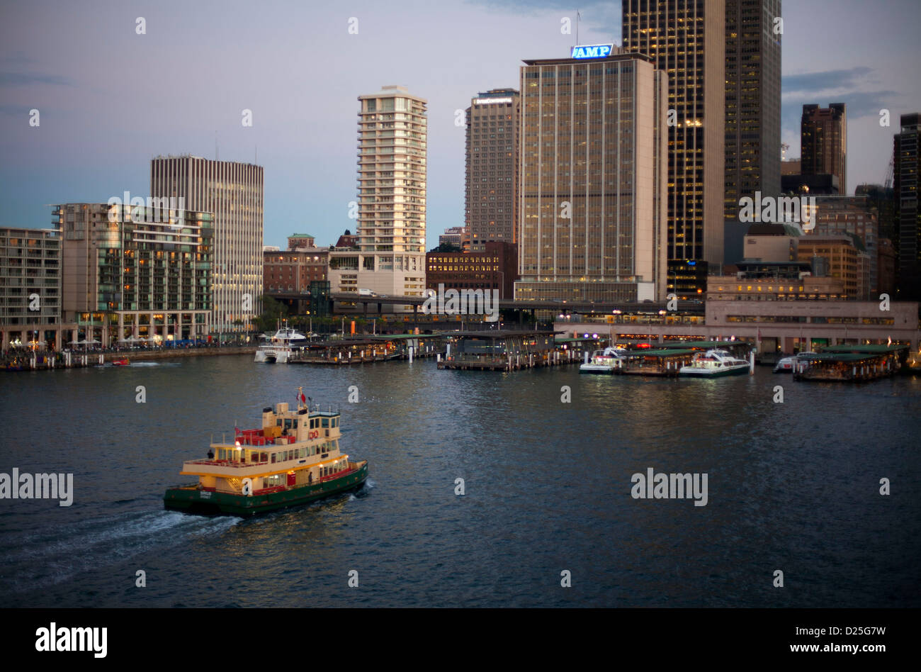 Sydney Harbour Ferry Katamaran Ankunft am Circular Quay Ferry Terminal bei Sonnenuntergang mit Sydney CBD im Hintergrund Stockfoto