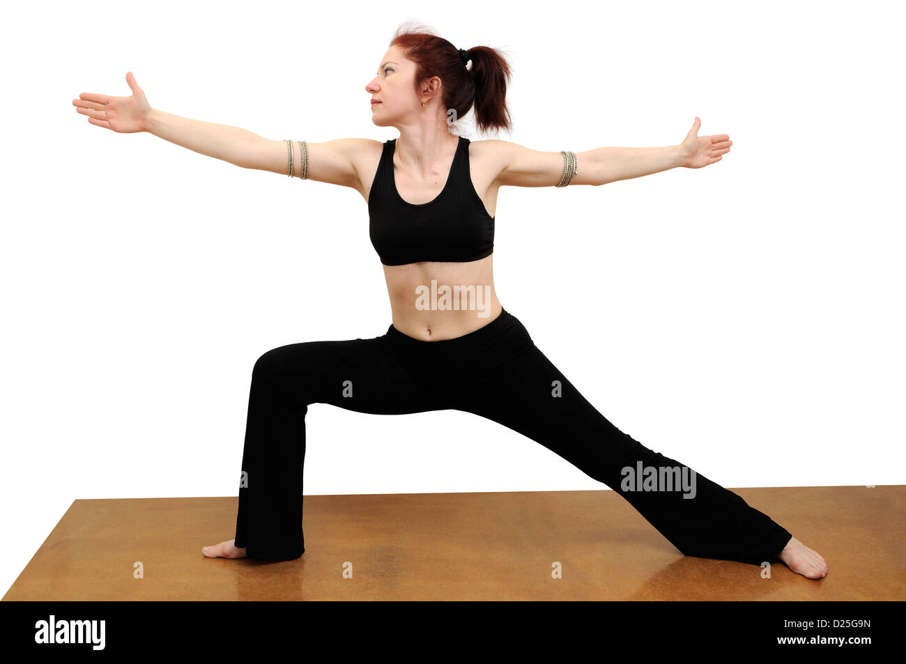 Frau in Yogastellung Krieger auf einem blauen Teppich Stockfoto