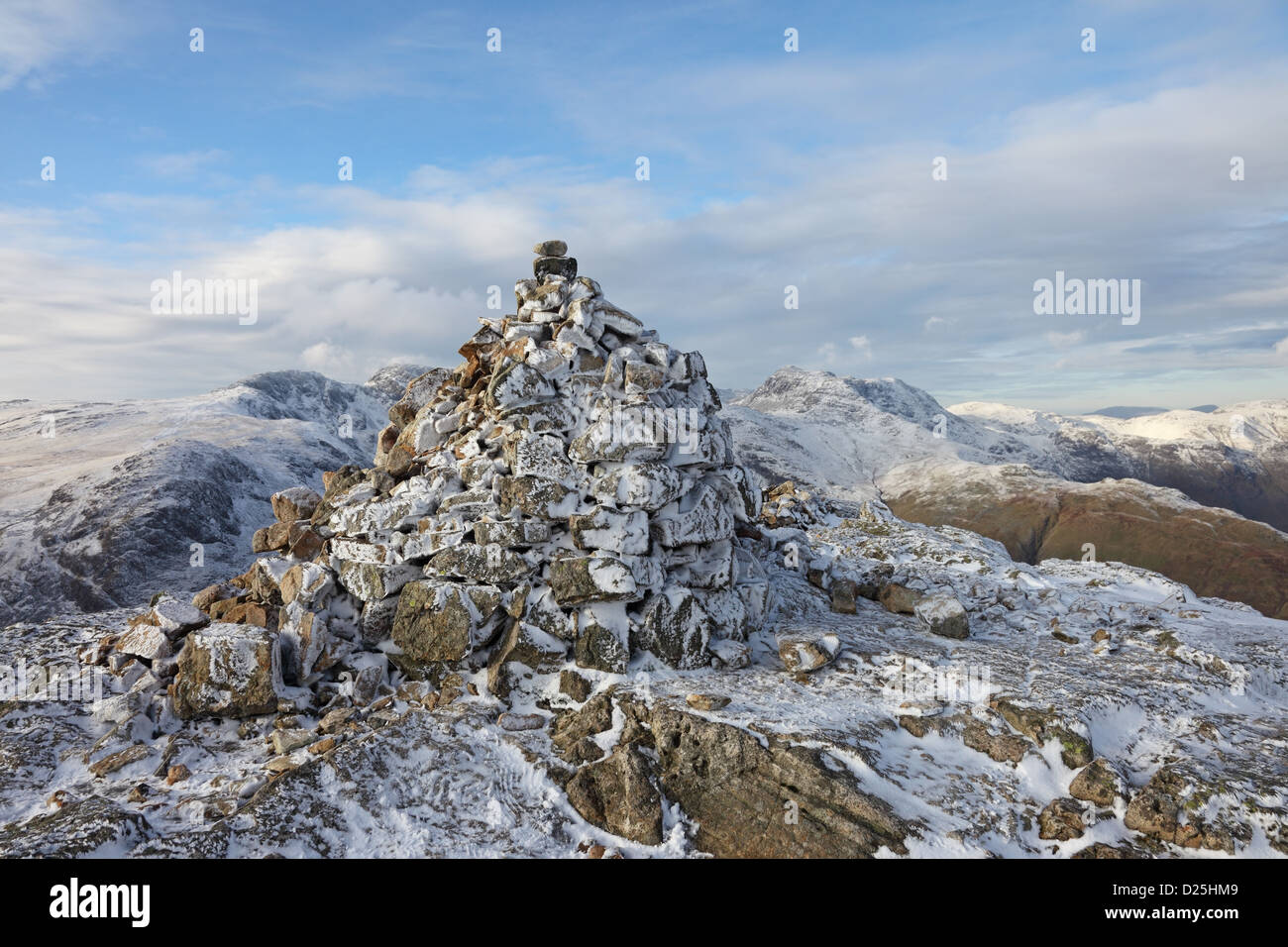 Der Gipfel Cairn von Pike Blisko im Winter mit Crinkle Crags und Bogen fiel hinter Seenplatte Cumbria UK Stockfoto