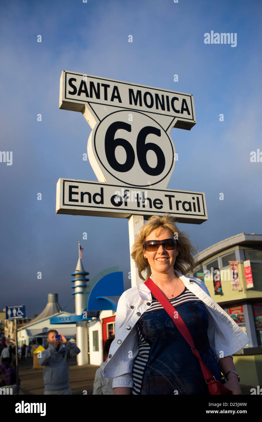 Ende der Route 66 Trail Zeichen am Santa Monica Pier mit Frau unten stehen Stockfoto
