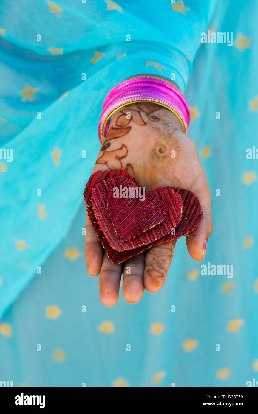 Indische Mädchen Hand 3 Red Coconut husk Rinde Herzformen. Indien Stockfoto