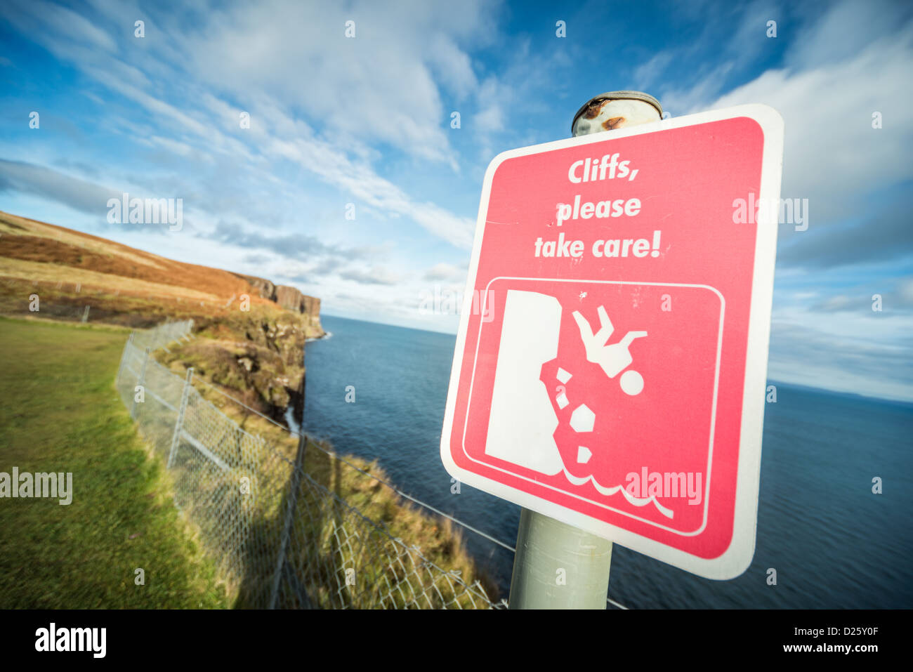 Klippen, achten Sie bitte darauf! Schild am Kilt Rock, Isle Of Skye, Schottland mit der blauen Seanand Skye im Hintergrund Stockfoto