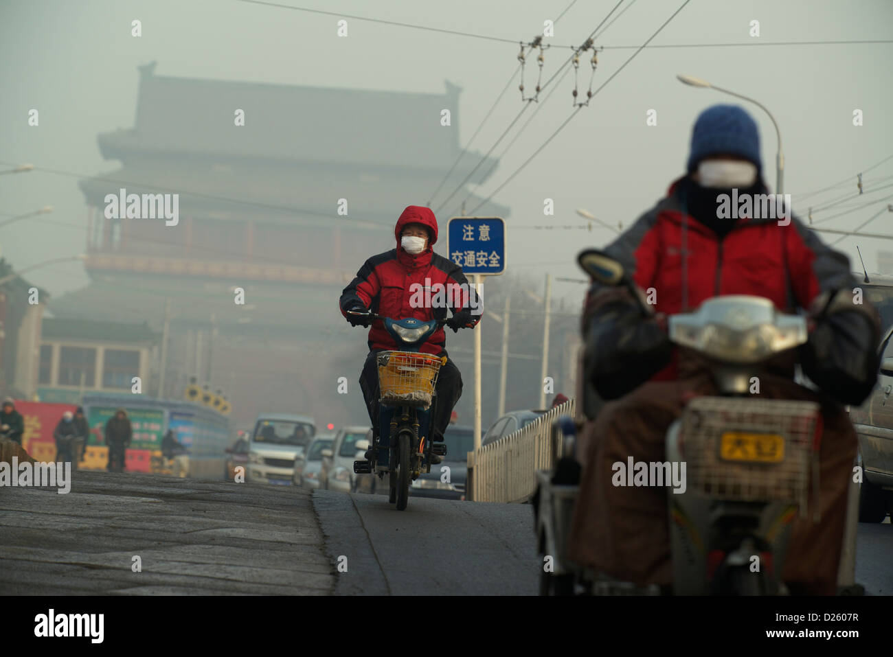 Mann trägt eine Maske in schweren Smog vor Trommelturm in Peking, China. 14. Januar 2013 Stockfoto