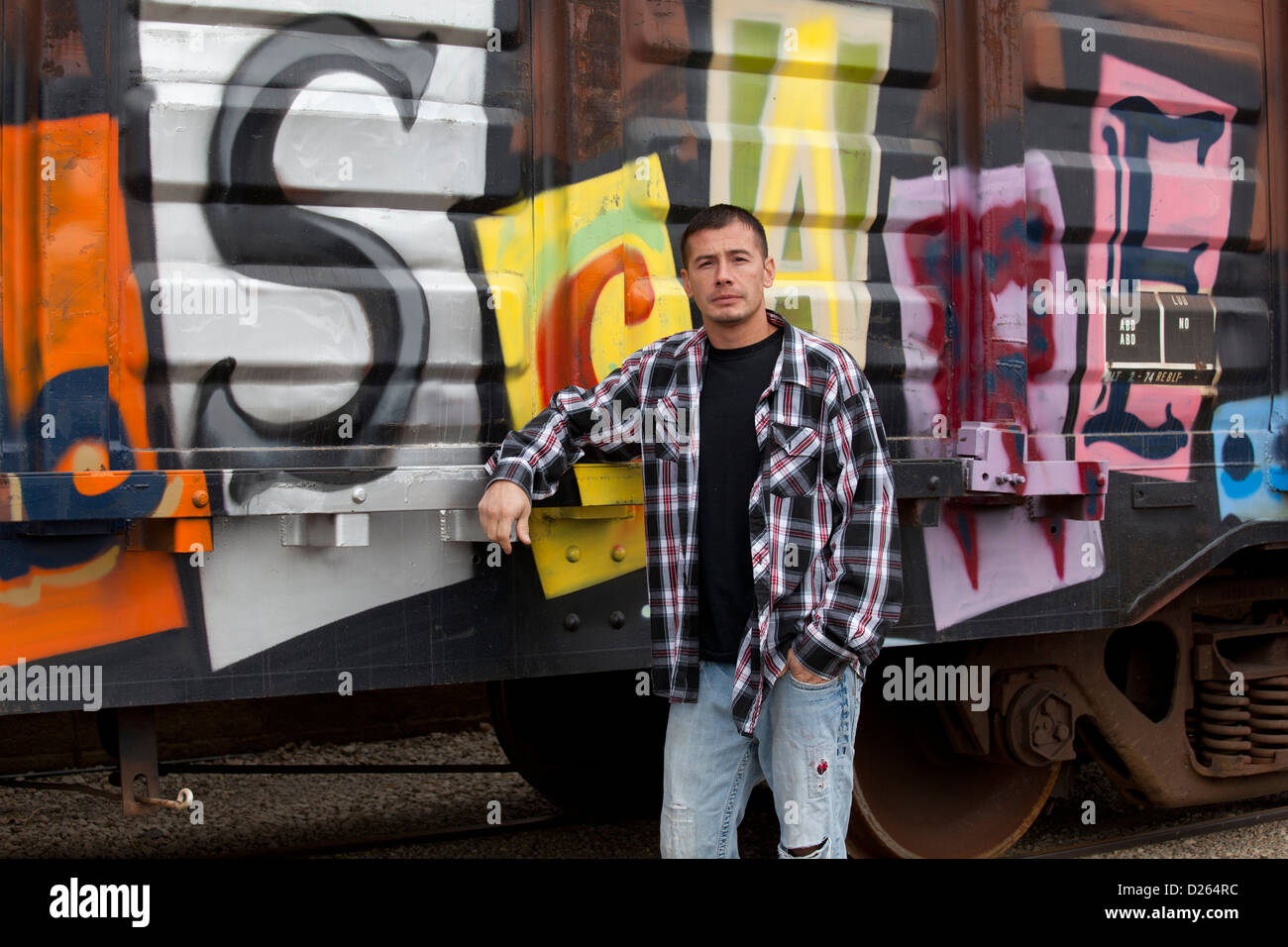 Harter Kerl stehen neben einem Graffiti bedeckt-Zug Stockfoto