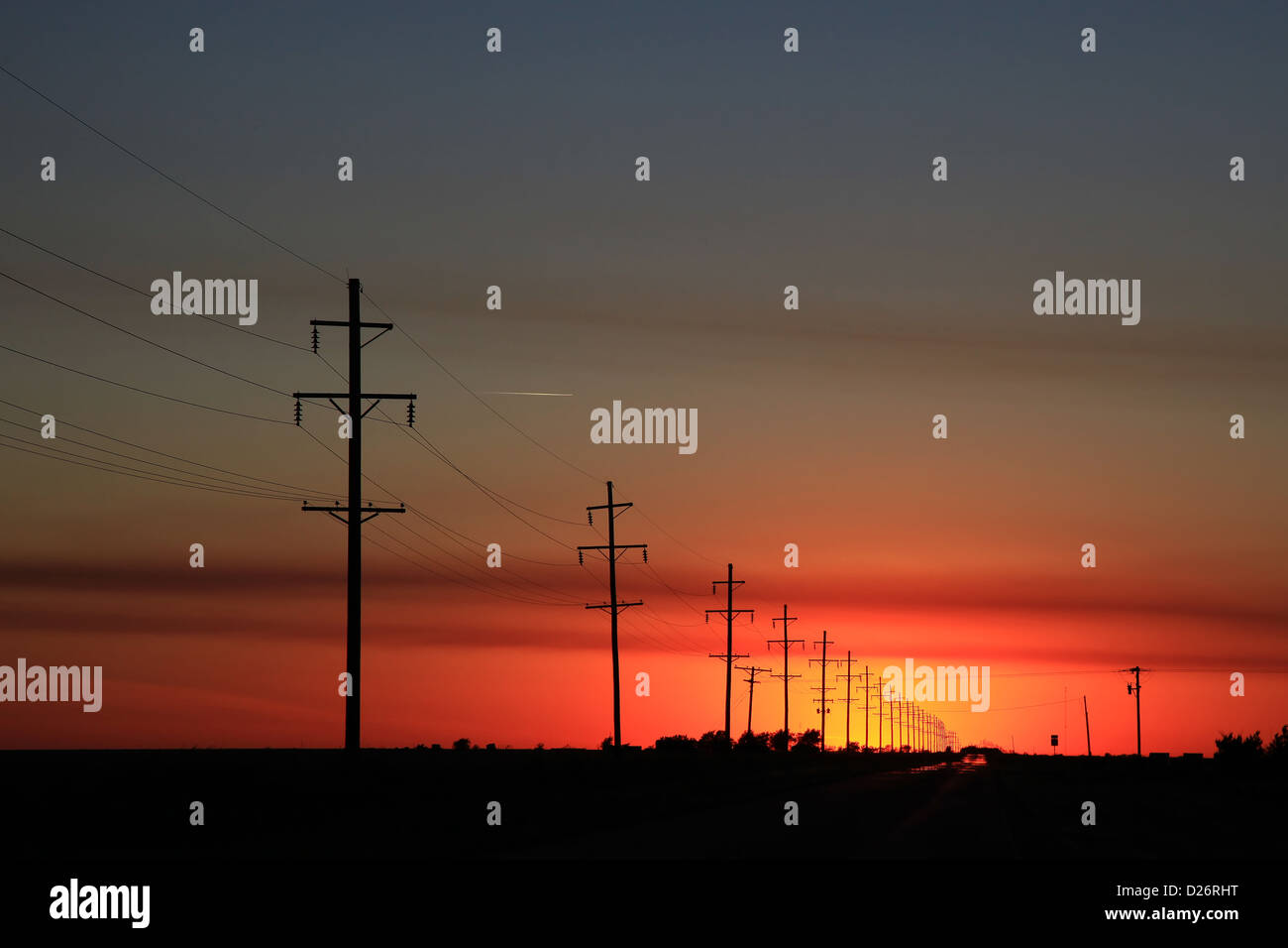 Reihe von Strommasten bei Sonnenuntergang Stockfoto