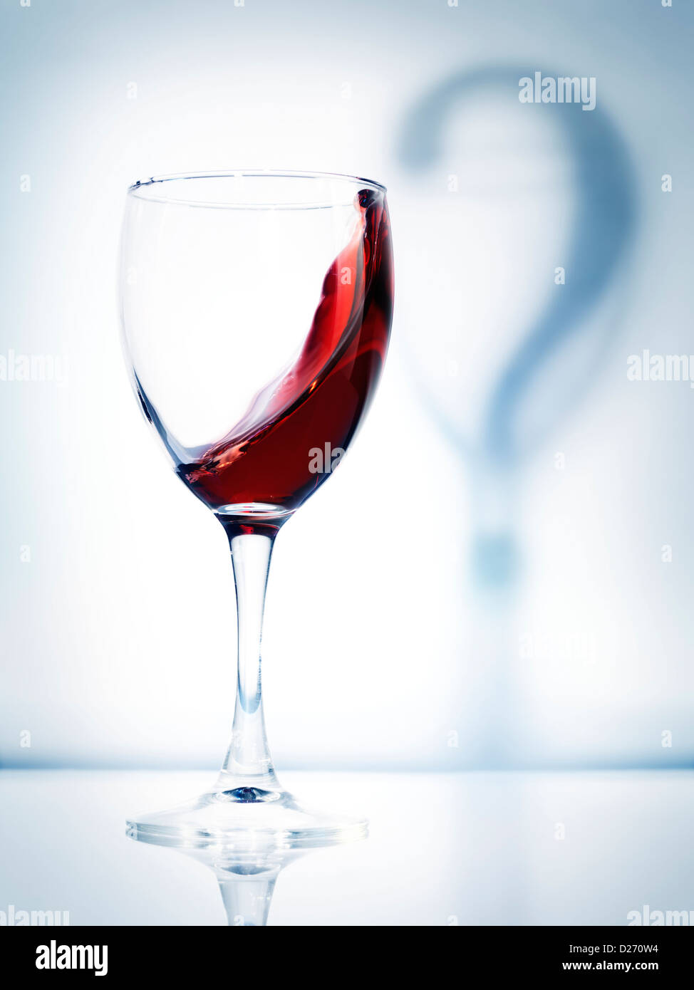 Glas Rotwein und ein Schatten Fragezeichen künstlerische konzeptionelle Foto auf hellblauem Hintergrund isoliert Stockfoto
