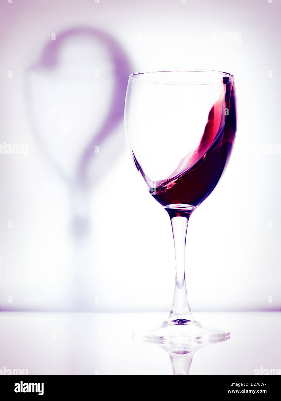 Rotwein in ein Glas und Schatten ein Fragezeichen künstlerische konzeptionelle Foto isoliert auf weißem Hintergrund Lila Stockfoto