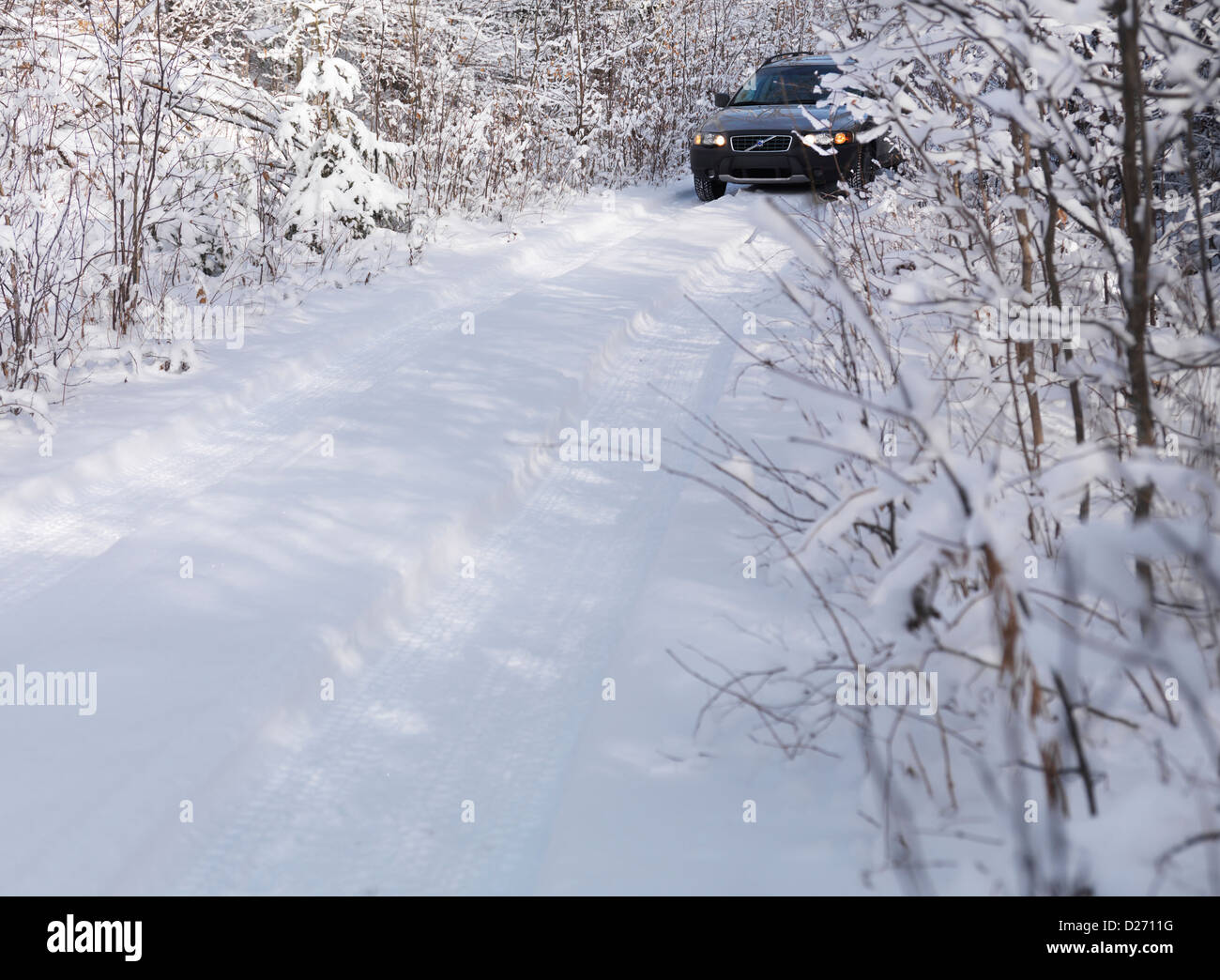 Volvo XC70 Auto auf Schnee bedeckt unbefestigte Landstraße, malerische Winterlandschaft. Stockfoto