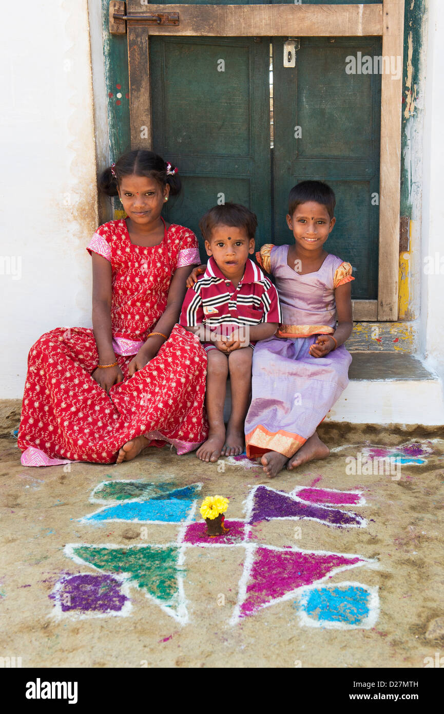Junge indische Dorfmädchen und junge sitzt vor der Tür ihres Hauses. Andhra Pradesh, Indien Stockfoto