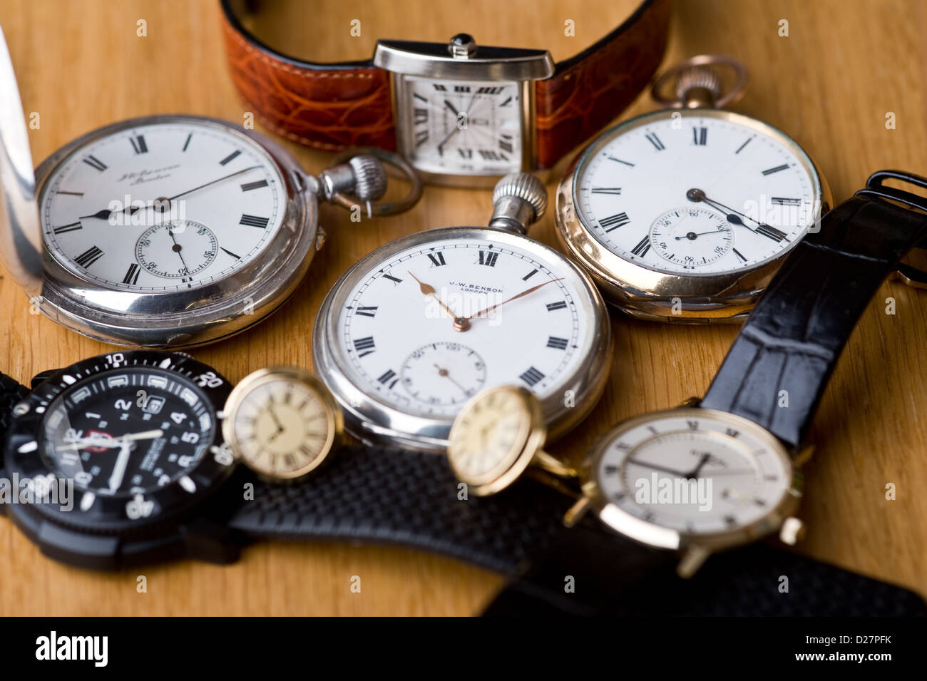 Gruppe von Taschenuhren und Armbanduhren, auf einer Eiche Tischplatte. Stockfoto