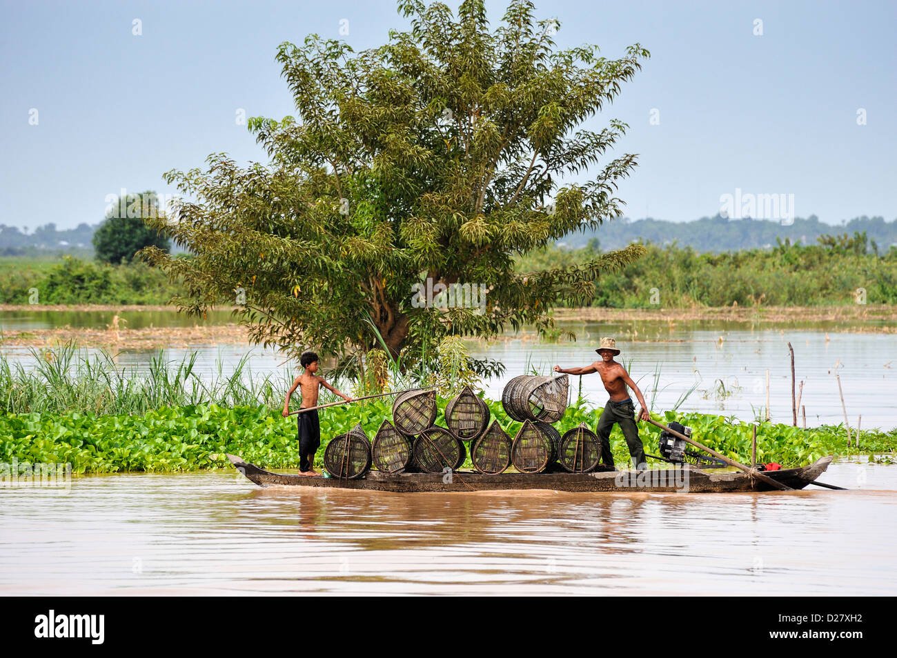 Mekong River, Kambodscha - Mann und der junge den Transport von Fischen fallen / Körbe Stockfoto
