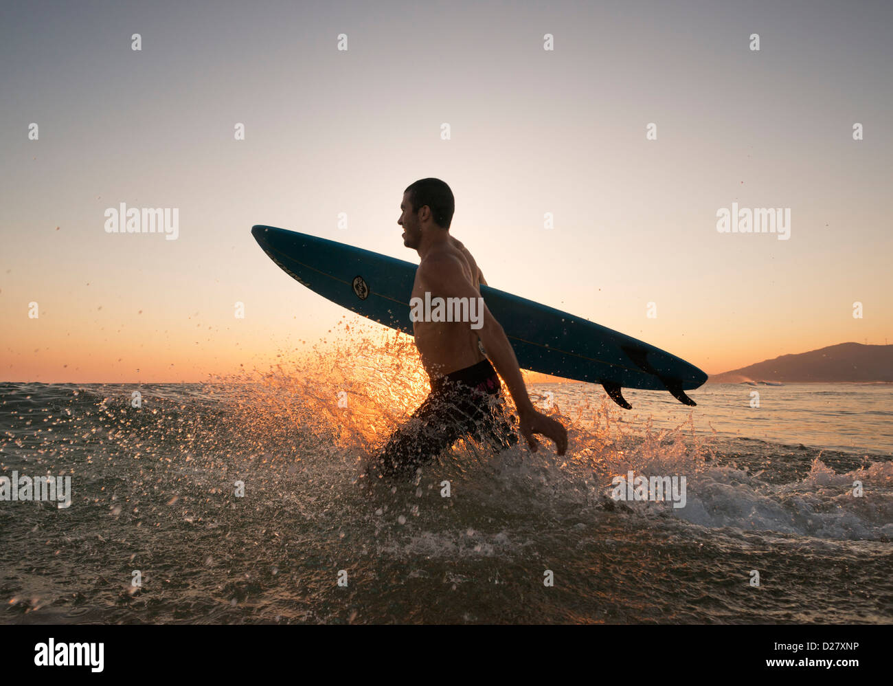 Surfer, die ins Meer laufen. Stockfoto
