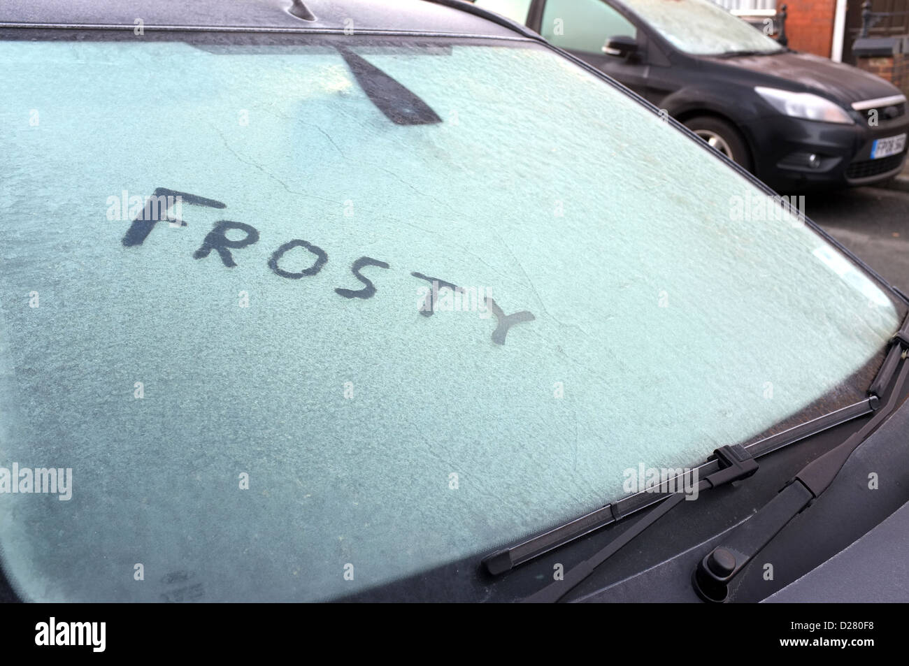 Eine gefrorene Windschutzscheibe mit dem Wort frostigen geschrieben im Eis Stockfoto