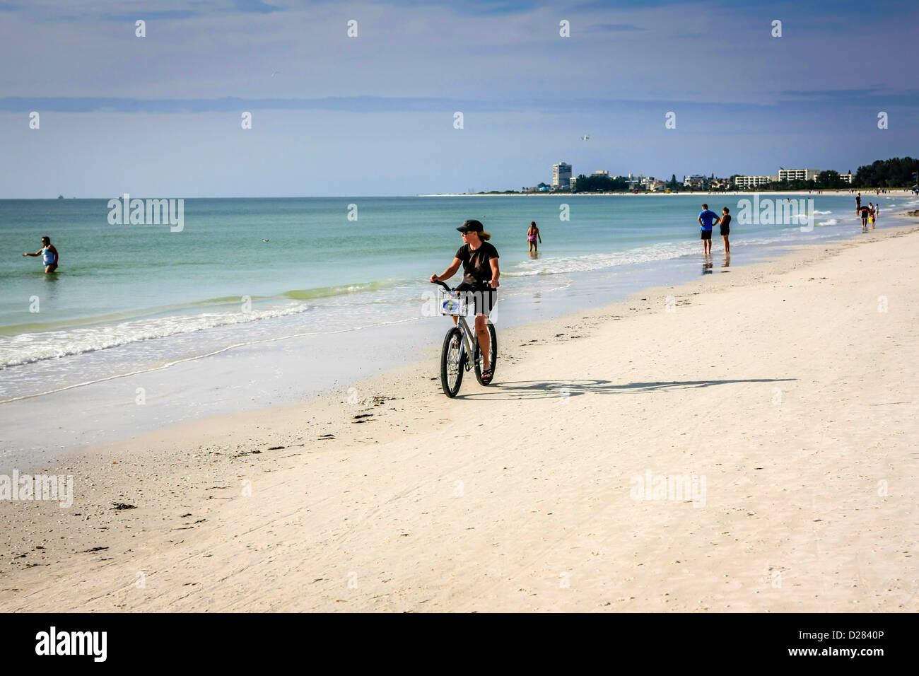 Frau Radfahren auf Siesta Key Beach an einem warmen Wintertag in Florida Stockfoto
