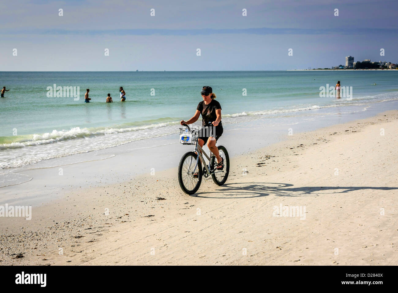Frau Radfahren auf Siesta Key Beach an einem warmen Wintertag in Florida Stockfoto