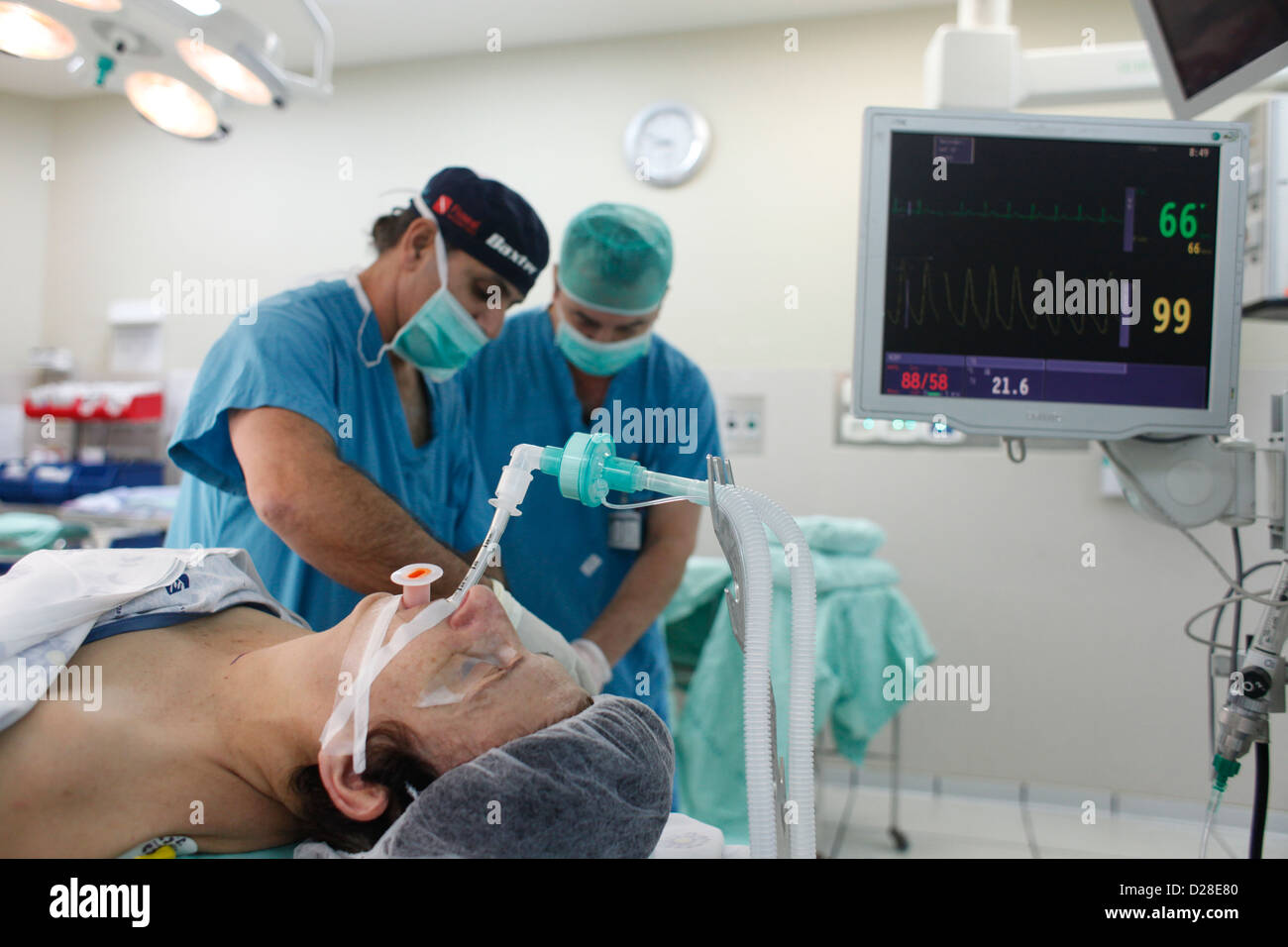 Anästhesisten, die chirurgische Masken mit einem Patienten mit oropharyngealem (OP) Atemwegsgerät in seinem Mund im Operationssaal des Rambam-Krankenhauses Haifa Israel tragen Stockfoto