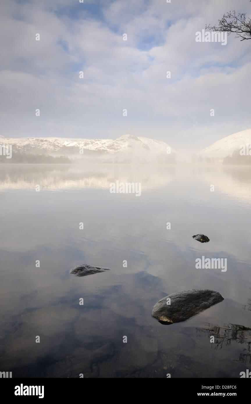 Clearing Schneewolke über Grasmere und Helm Crag im Winter im englischen Lake District Stockfoto