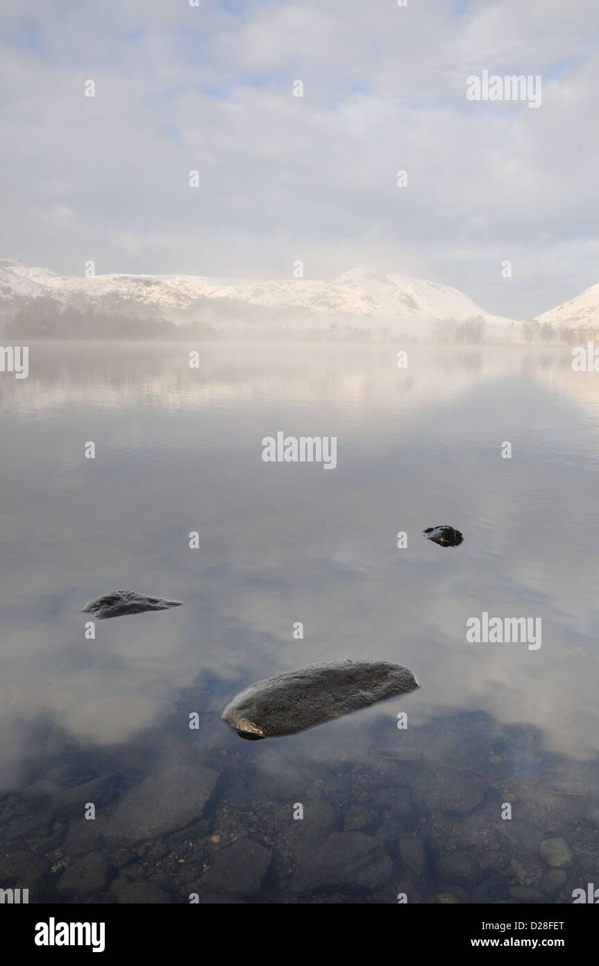 Clearing Schneewolke über Grasmere und Helm Crag im Winter im englischen Lake District Stockfoto