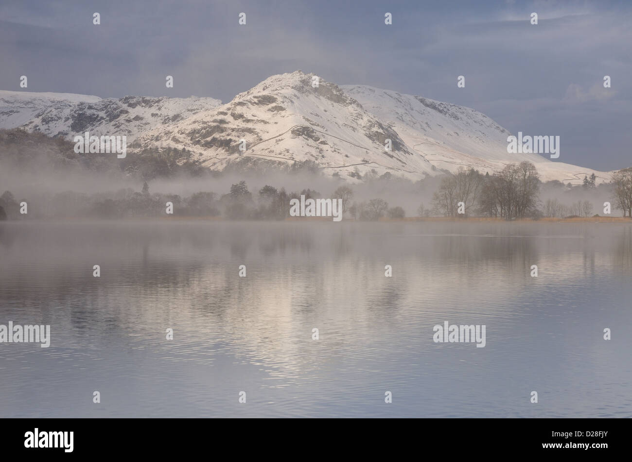 Clearing Schneewolke über Grasmere und Helm Crag im Winter im englischen Lake District Stockfoto