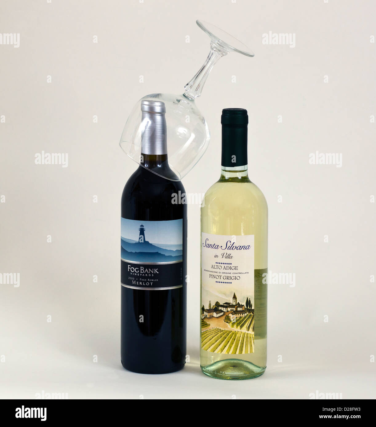 Zwei Flaschen Wein, eine rote und eine weiße mit einem Glas auf der Oberseite eine Flasche. Stockfoto