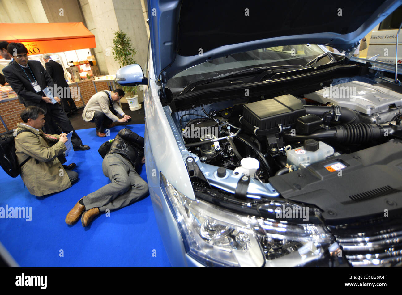 16. Januar 2013, Tokyo, Japan - nehmen Besucher einen genaueren Blick auf die Unterseite eines Elektrofahrzeugs während der Automotive World 2013 auf Mittwoch, 16. Januar 2013 in Tokio statt. Die dreitägige Messe präsentiert die modernsten Kfz-Technik zu wachsenden japanischen und asiatischen Automobilhersteller und ihre Zulieferer.  (Foto von Natsuki Sakai/AFLO) Stockfoto