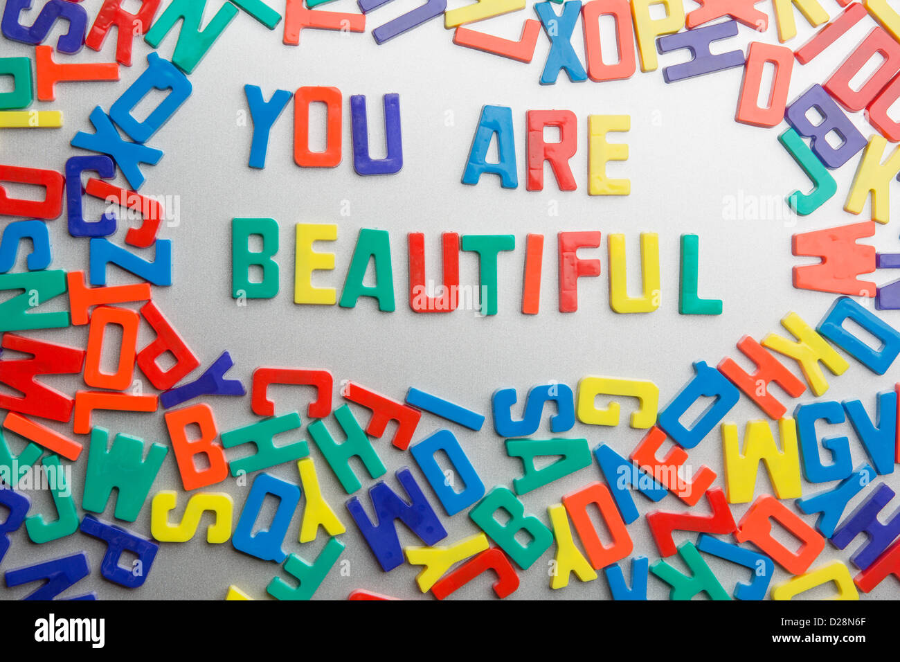 "Sie sind schön" - Kühlschrank-Magnete buchstabieren eine Nachricht aus einem Durcheinander von Buchstaben Stockfoto
