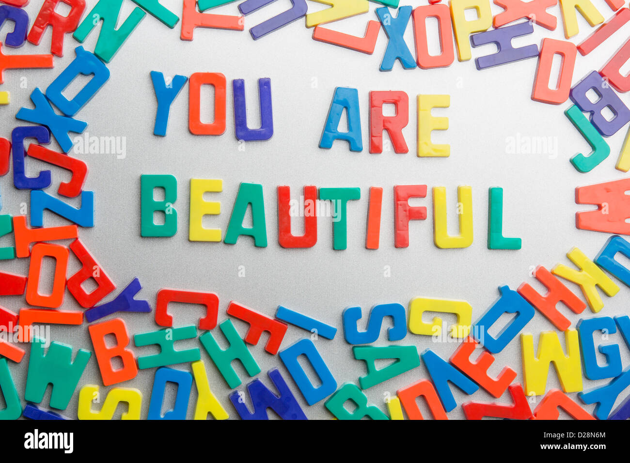 "Sie sind schön" - Kühlschrank-Magnete buchstabieren eine Nachricht aus einem Durcheinander von Buchstaben Stockfoto