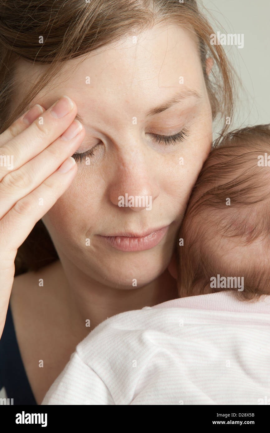 Erschöpfte Mutter halten baby Stockfoto