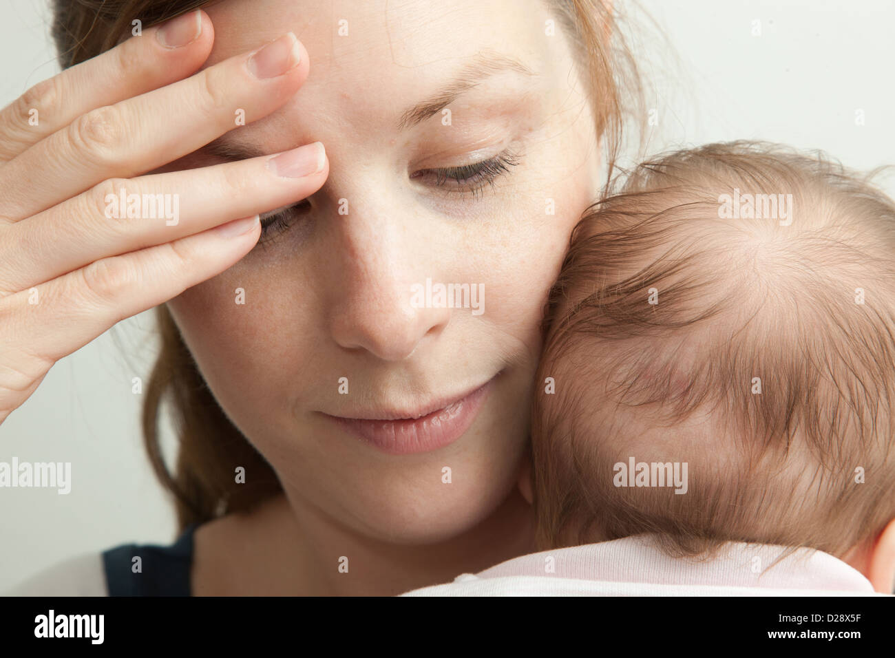 Erschöpfte Mutter halten junge baby Stockfoto