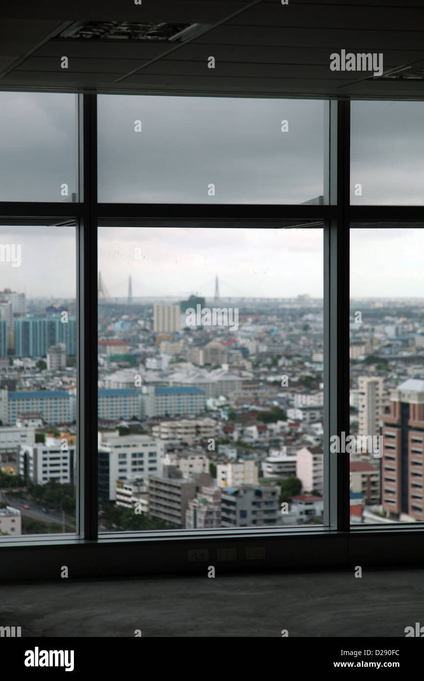 Es ist ein Foto von Bangkok in Thailand. Es ist ein Blick auf die Aussicht auf die Stadt von hoch oder den Himmel. Man sieht ihn durch ein Fenster Stockfoto