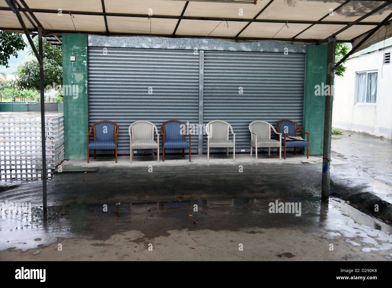 Es ist ein Foto von 6 Stühlen oder Sitze, die nebeneinander vor ein Closed Shop in Hong Kong stehen Stockfoto