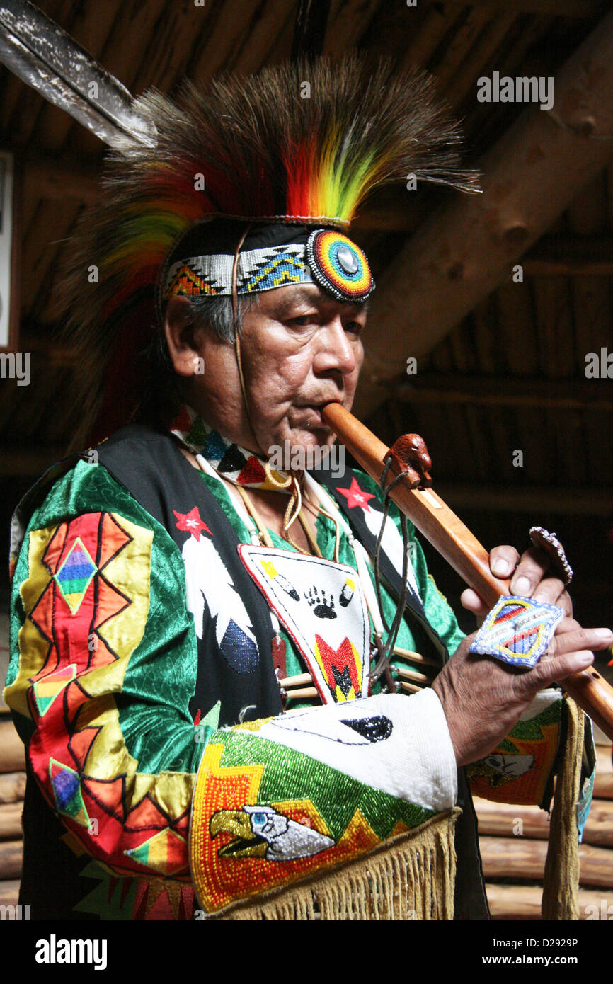 Shuswap Kulturführer indische Flötenspiel innen Grubenhaus im historischen Hat Creek Ranch Native Village, B.C.,Canada Stockfoto