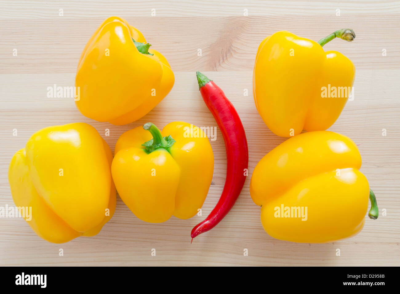 fünf süße Gelbe Paprika und eine rote hot Chili pepper Stockfoto