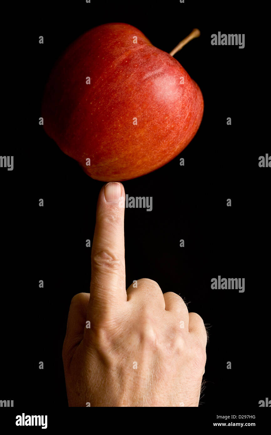 Einen Apfel auf die Fingerspitze Abwägung Stockfoto