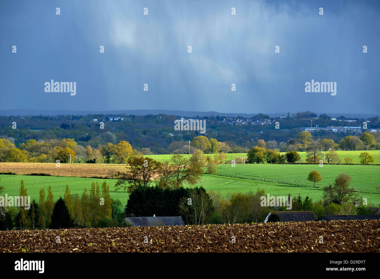 Ackerland im Frühjahr (April), Regen, Wiesen und Kulturen getrennt durch Hecken (Norden Mayenne, Pays de la Loire, Frankreich, Europa). Stockfoto