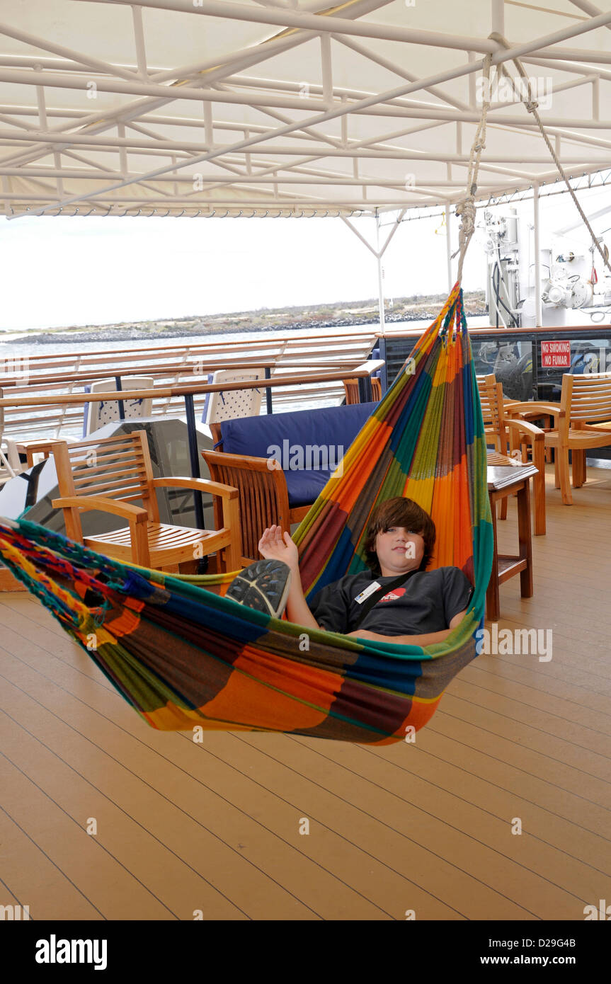 Ecuador, Galapagos-Inseln, 11-Year-Old Boy auf Kreuzfahrt Schiffsdeck, Hängematte Stockfoto