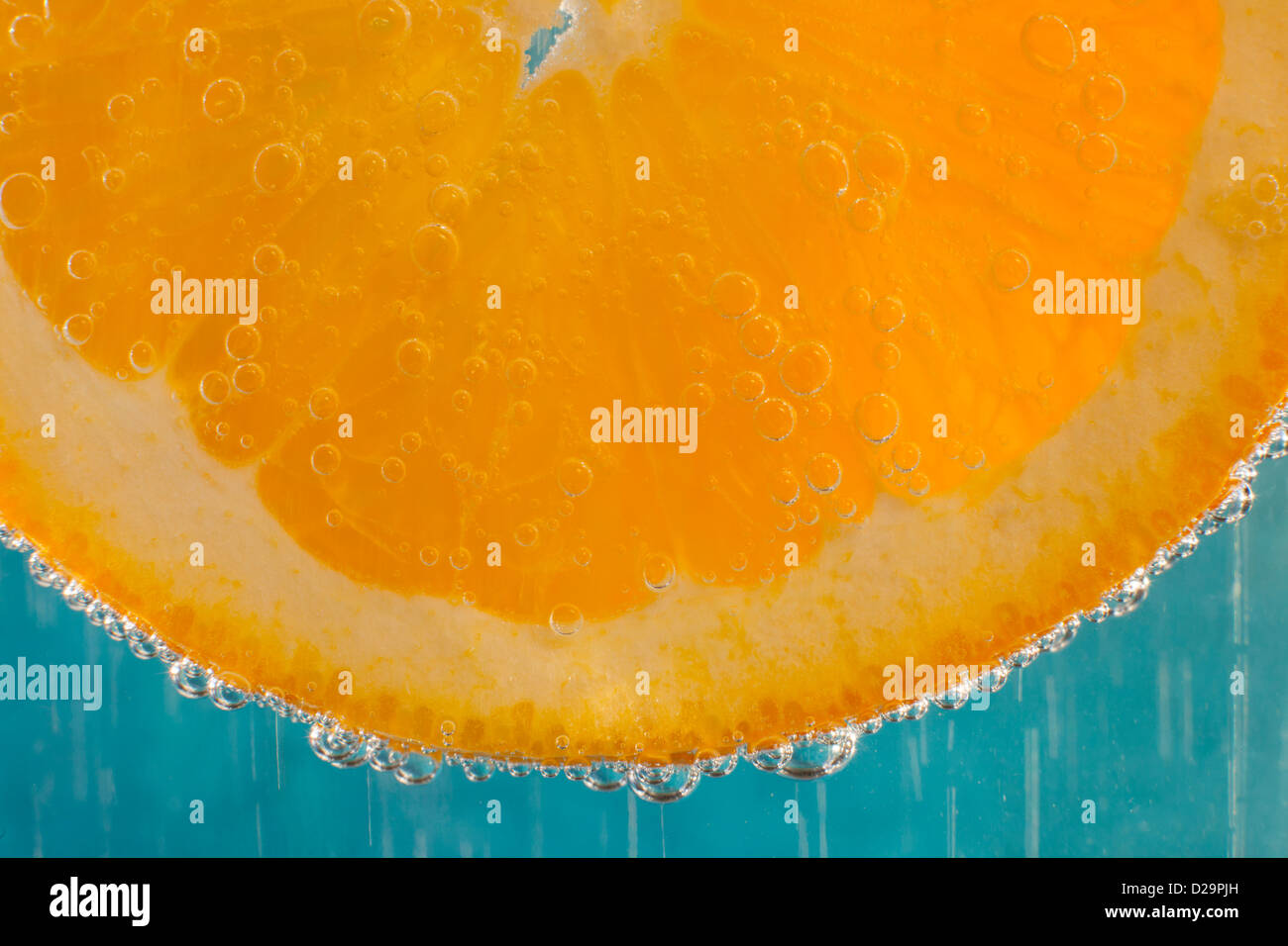 Eine Orangenscheibe in einem Glas Mineralwasser Stockfoto