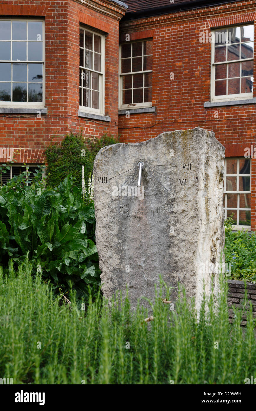 Stone Sonnenuhr im Klostergarten mit Abbey House im Hintergrund. Winchester, Hampshire, UK Stockfoto