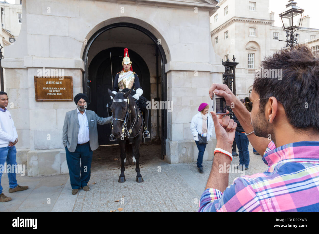 Sikh touristischen posiert für ein Foto neben montierten Soldat der "Blues and Royals" Haushalt Kavallerie Horseguards Parade. Stockfoto